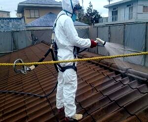 アスベスト飛散防止のために屋根周りの囲い込みと湿潤化を行っている写真